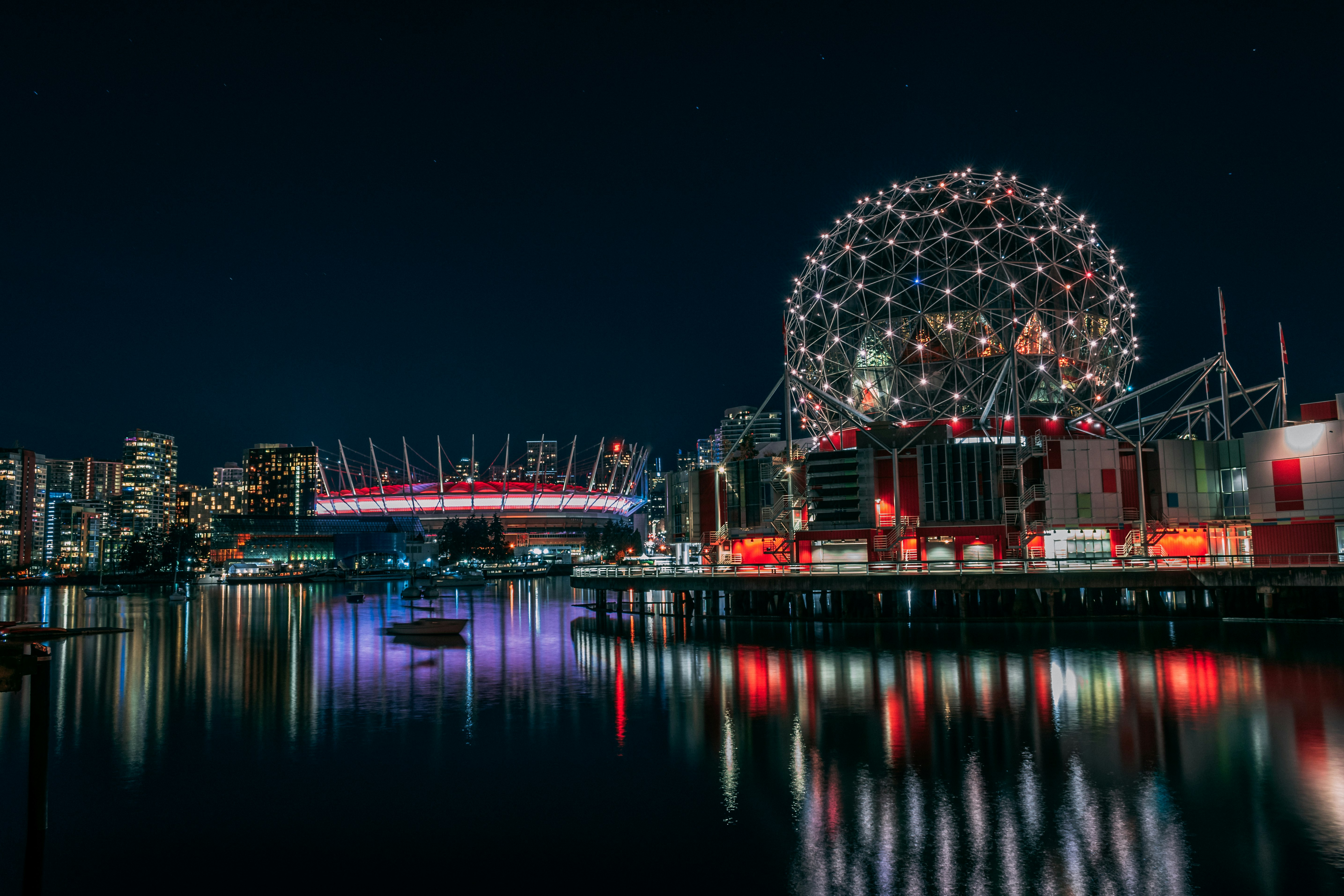 skyline photography of boat passing on waters overlooking buildings